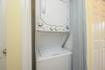 For your convenience, a laundry closet with a stacked washer and dryer